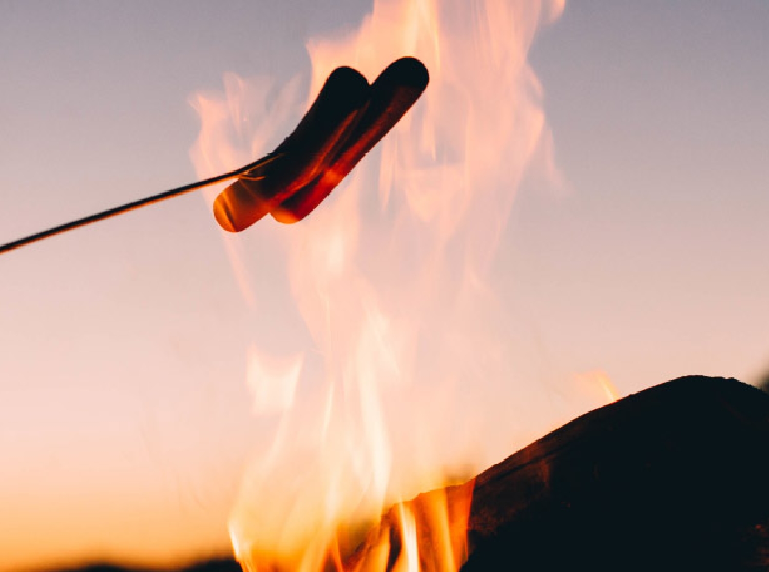 Geroestete Marshmallows ueber offenem Feuer.