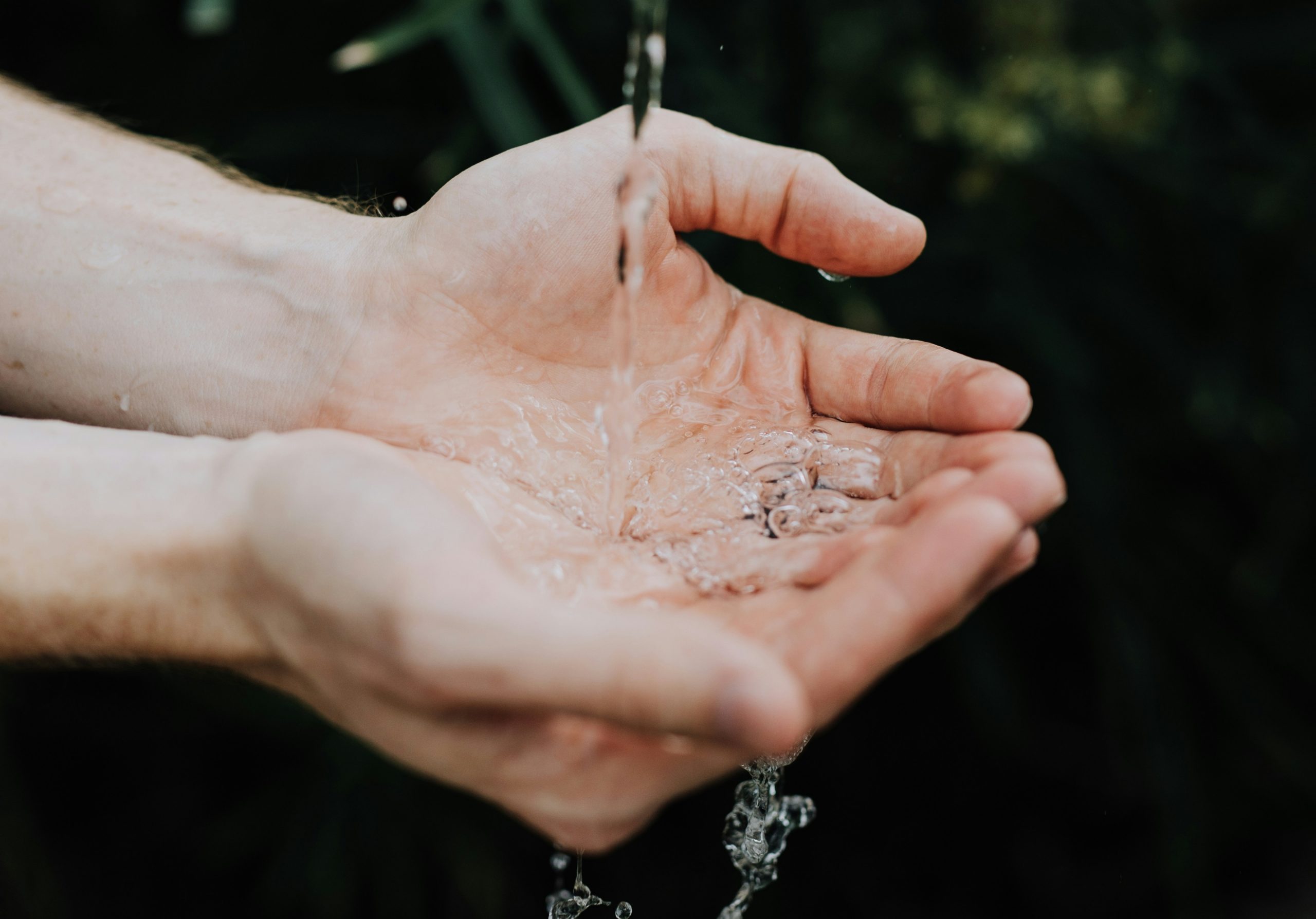 Haende unter fliessendem Wasser.